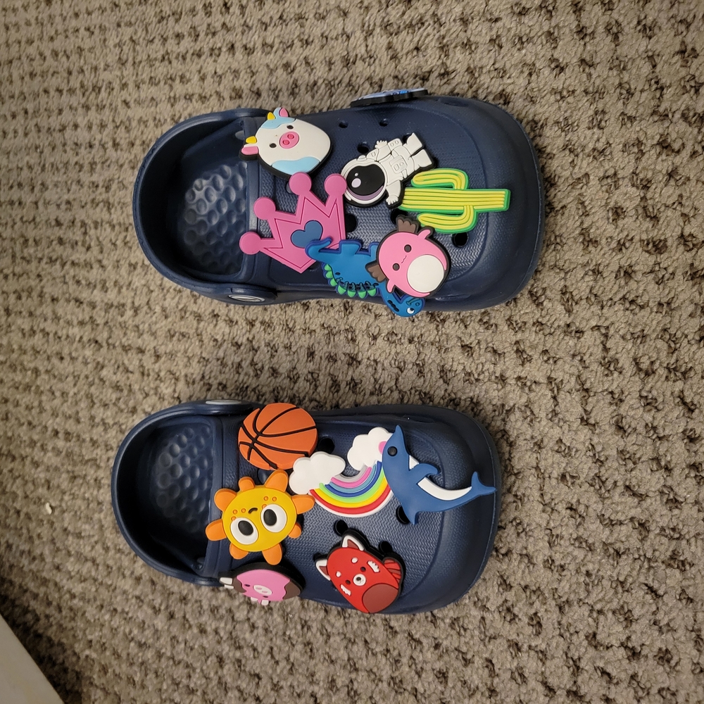 Blue Crocs-style shoes with colorful charms and textured surface